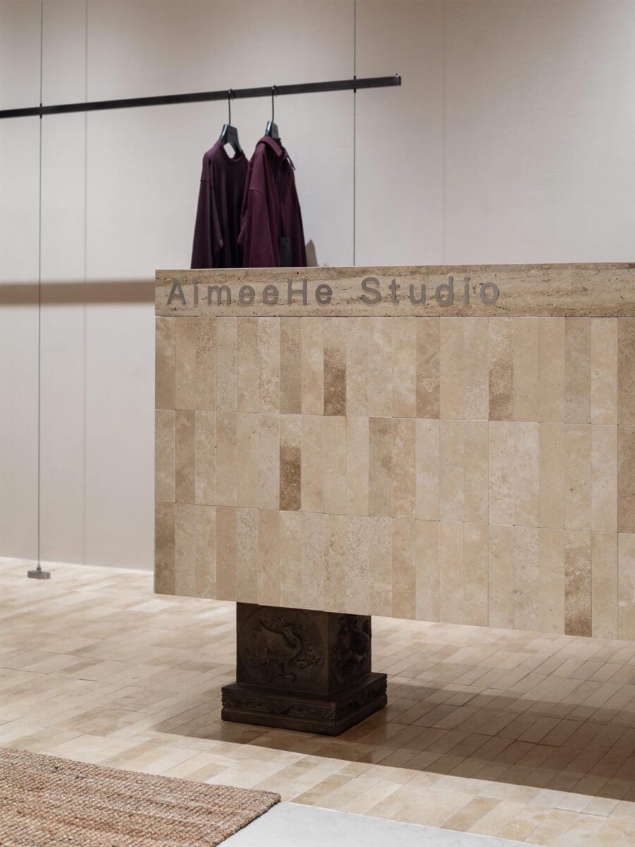 AimeeHe Studio retail store in Shenzhen, display counter clad in natural stone with engraved logo and sculptural central structure