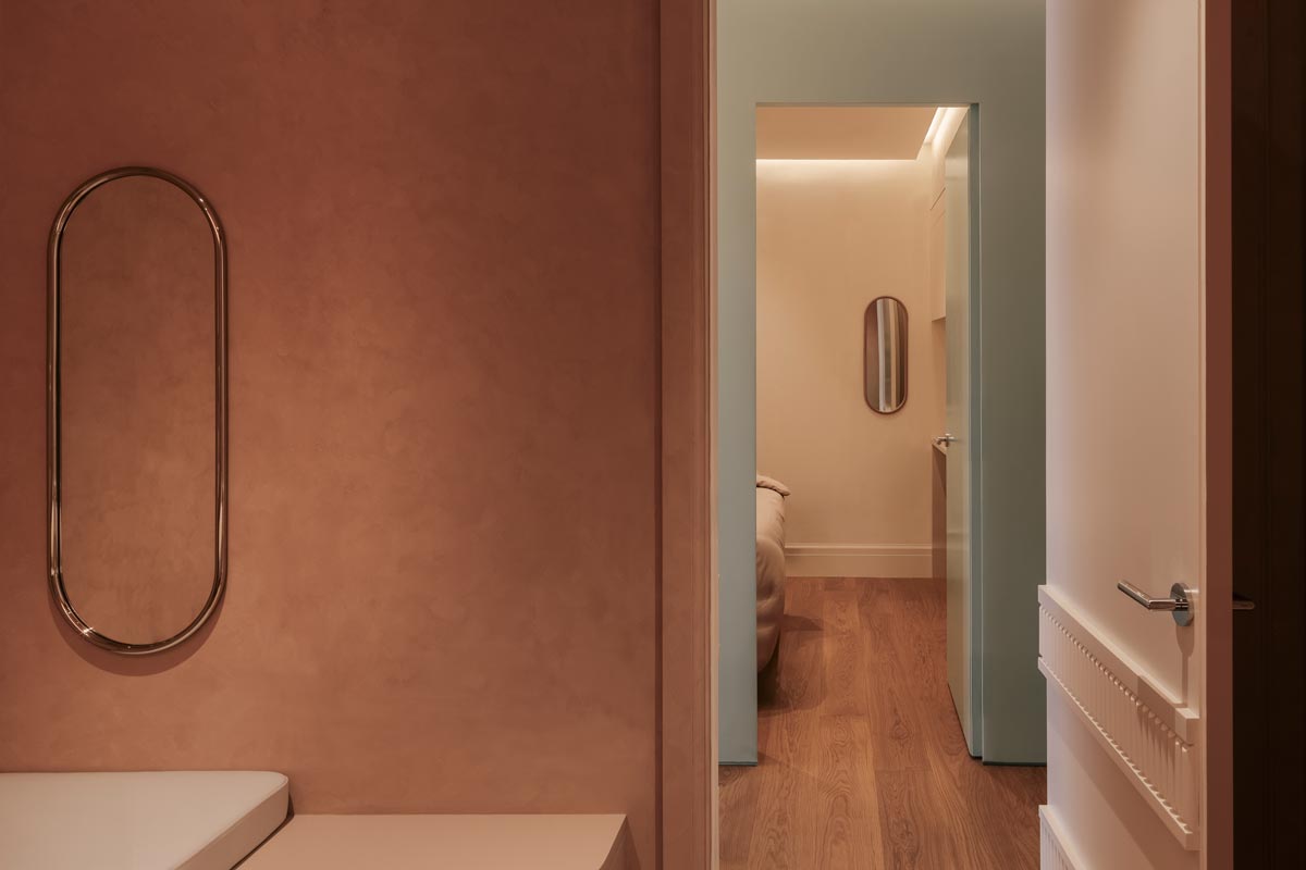 Entrance to a treatment room in the Living Beauty spa featuring lime plaster finishes, wooden flooring, and indirect ceiling lighting.
