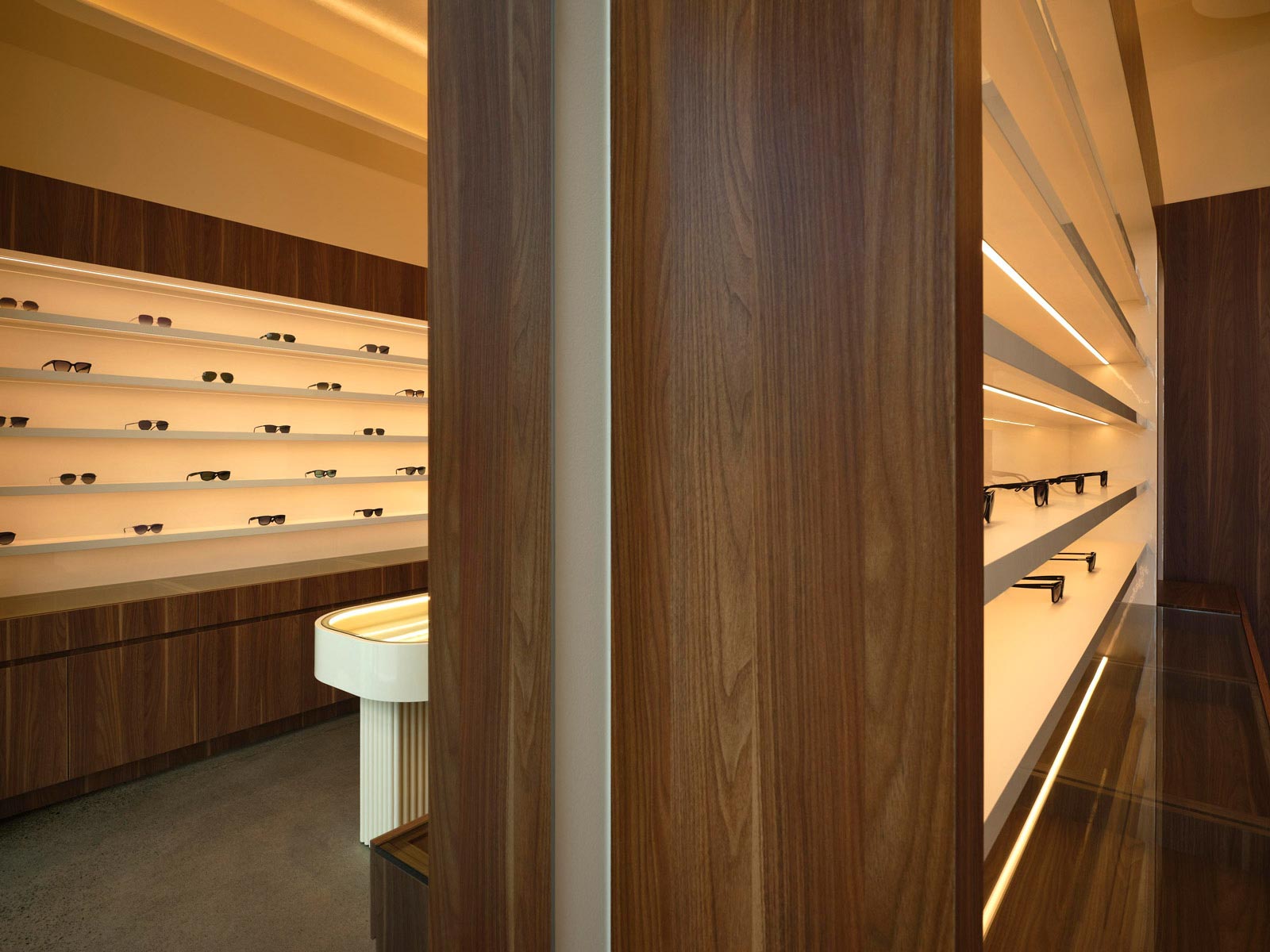 Interno boutique di ottica con palette avorio e legno scuro