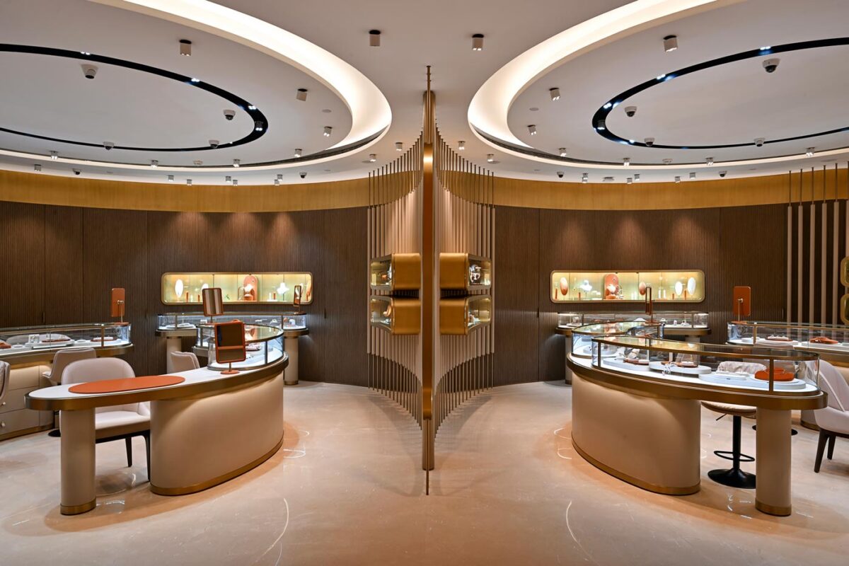 Contemporary jewellery store interior with curved layout, concentric ceiling light rings and brass and glass display counters, Eish Jewels by SEZA Architects in Indore