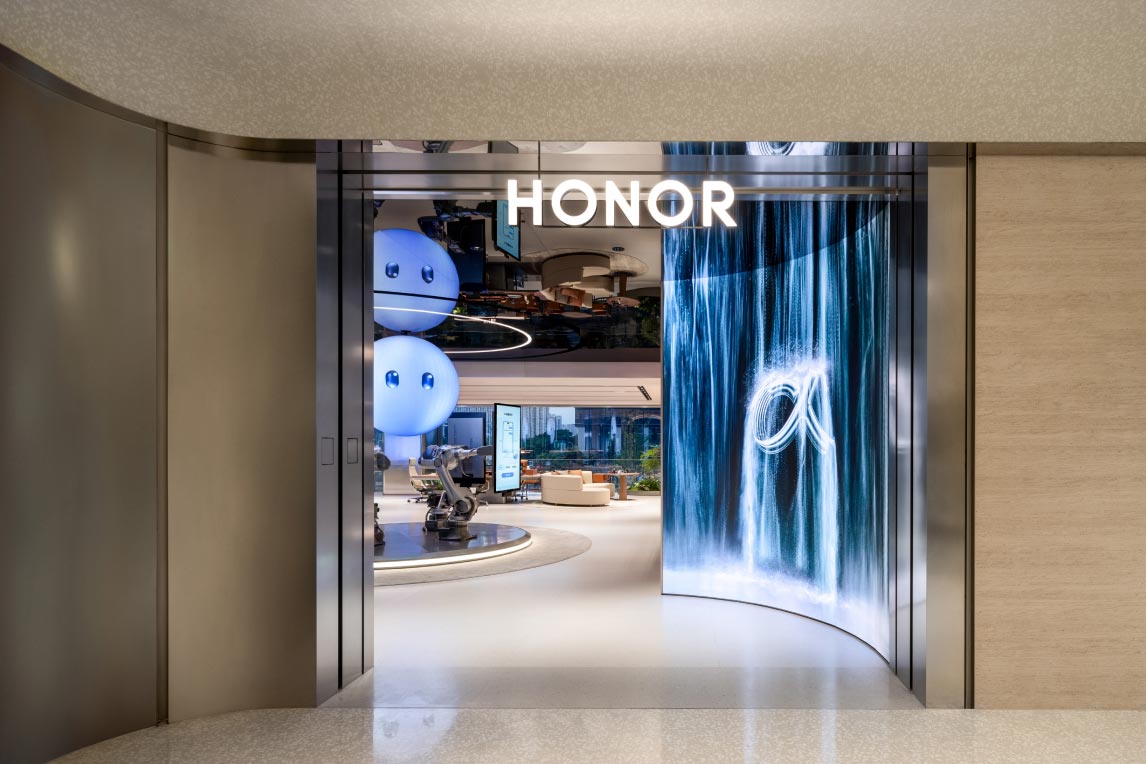 Ingresso dell’HONOR Flagship Store Shenzhen Bay con portale luminoso, schermo curvo con grafica digitale e vista sull’area interna