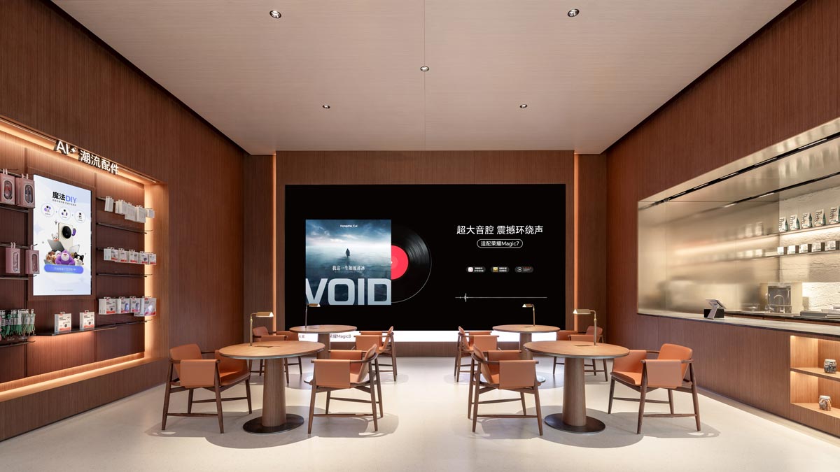 Area lounge interna con tavoli, sedute e grande schermo digitale nell’HONOR Flagship Store Shenzhen Bay