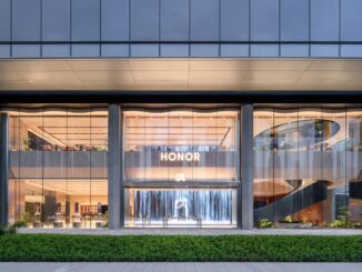 Facciata in vetro dell’HONOR Flagship Store Shenzhen Bay con ingresso trasparente e scala elicoidale visibile dall’esterno