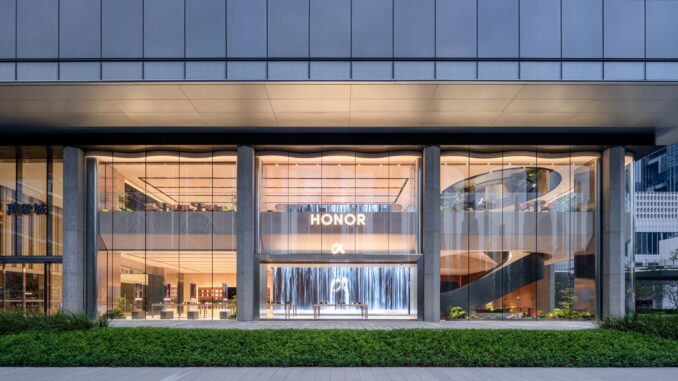 Facciata in vetro dell’HONOR Flagship Store Shenzhen Bay con ingresso trasparente e scala elicoidale visibile dall’esterno