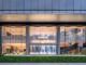 Facciata in vetro dell’HONOR Flagship Store Shenzhen Bay con ingresso trasparente e scala elicoidale visibile dall’esterno
