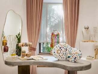 Interno della Gioielleria Outhouse a Goa progettata da Studio Hasta, tavolo espositivo in pietra con gioielli, elementi scultorei e tende rosa salmone