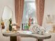 Interno della Gioielleria Outhouse a Goa progettata da Studio Hasta, tavolo espositivo in pietra con gioielli, elementi scultorei e tende rosa salmone
