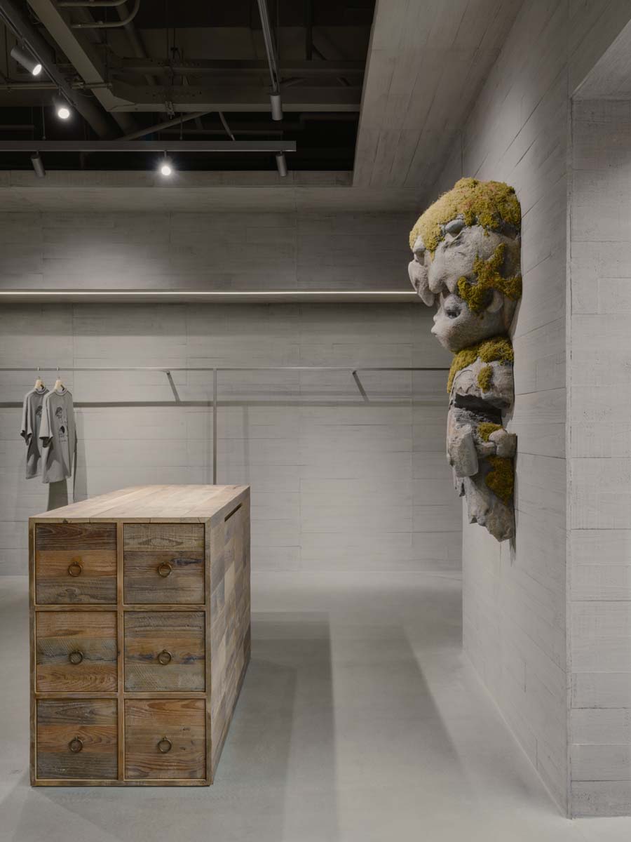 Detail of the Hirono sculpture and wooden storage display in a minimal concrete interior