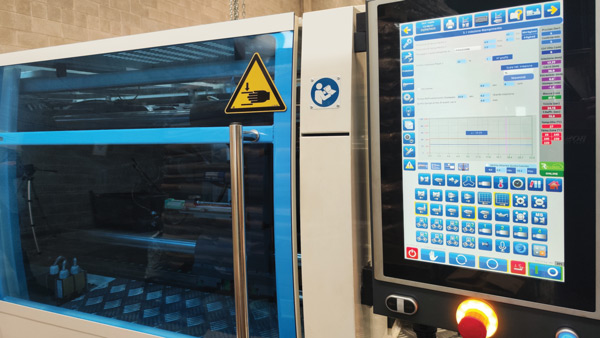 CNC machine processing plastic components used for retail price tags and visual merchandising displays.