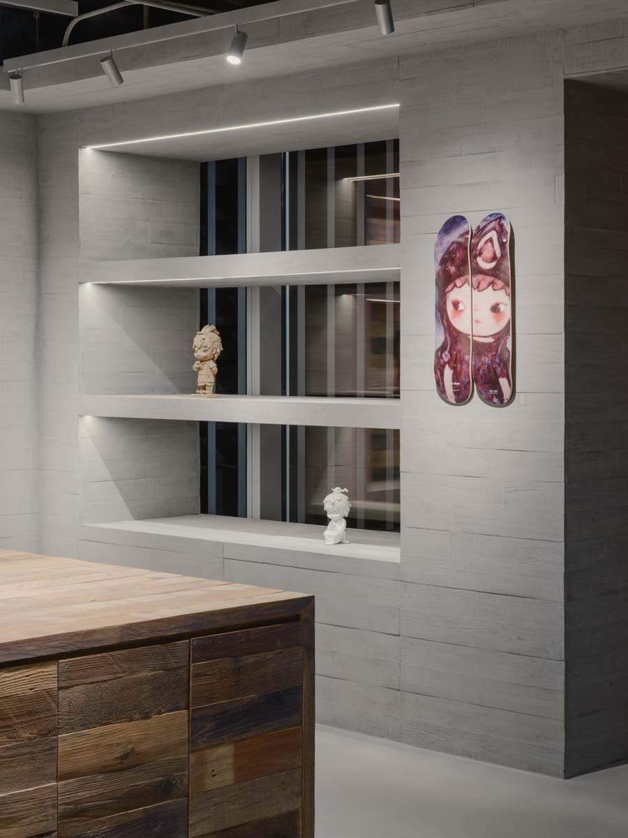 Backlit display niches in the Hirono store in Shanghai with collectible objects and decorative wall panel
