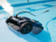 Robot pulitore automatico per piscina, di colore nero, immerso nell’acqua limpida mentre pulisce il fondo, con cavo visibile e riflessi di luce sulla superficie.