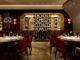 Sala ristorante SAMMARCO a Toronto con arredi in pelle rossa, pareti lignee e wine display retroilluminato