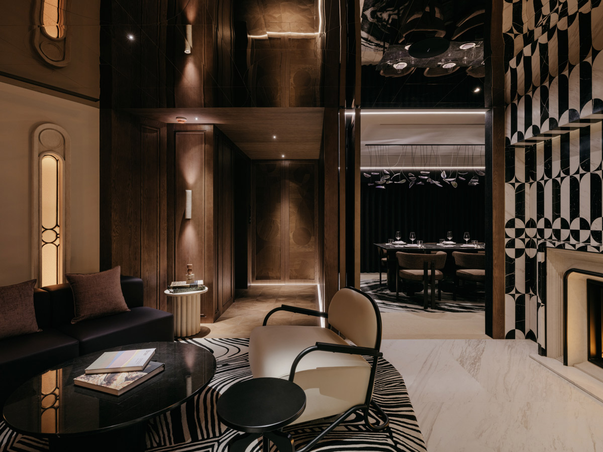 Lounge area of Aster restaurant in Shanghai with upholstered seating and view of private dining room with suspended lighting installation