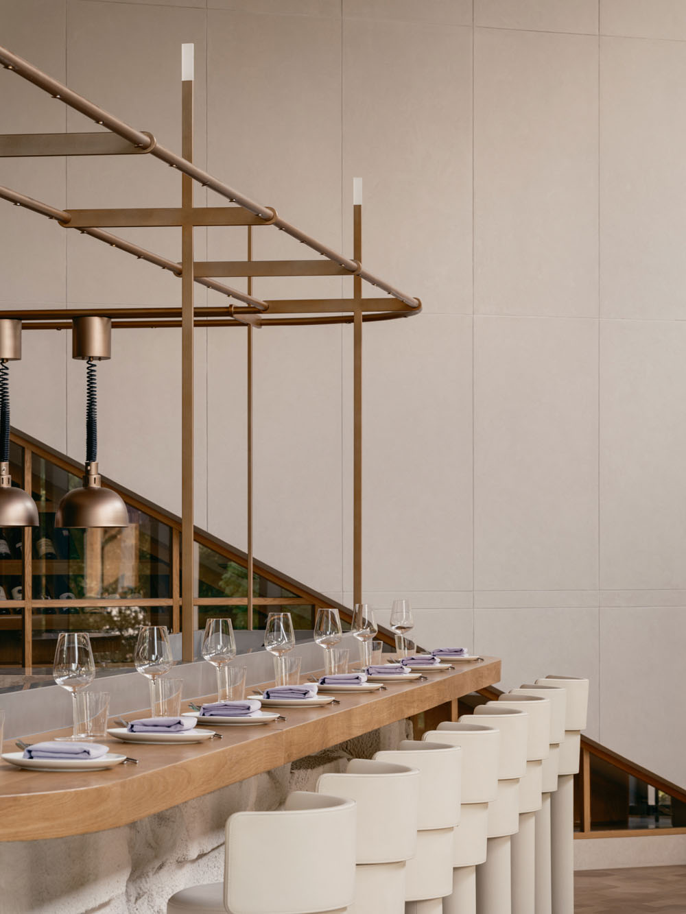 Lounge area of Aster restaurant with wood paneling and view toward private dining space