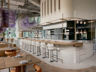 Ristorante Aster a Shanghai con bancone centrale circolare in argilla, cucina a vista e installazioni luminose sospese in tonalità viola