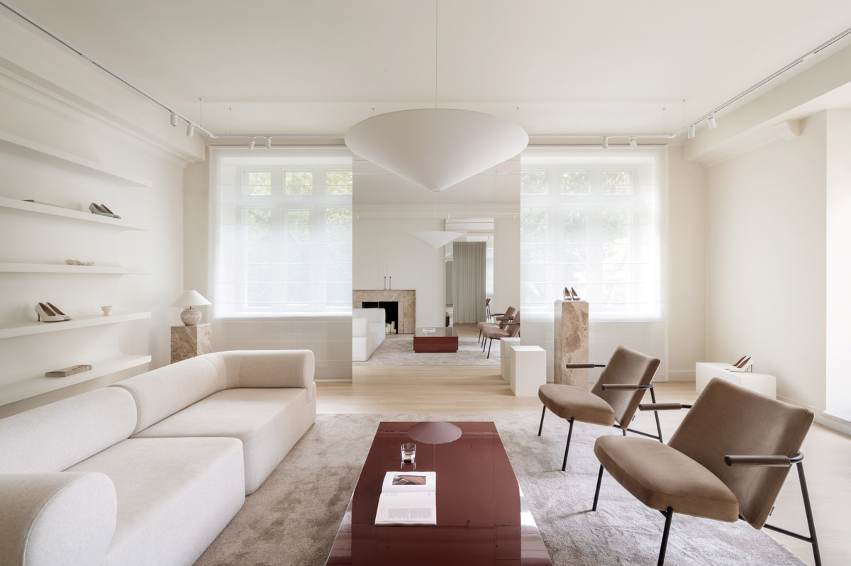 Marsala showroom in Kyiv with lounge area, curved sofa, upholstered armchairs and burgundy lacquered coffee table