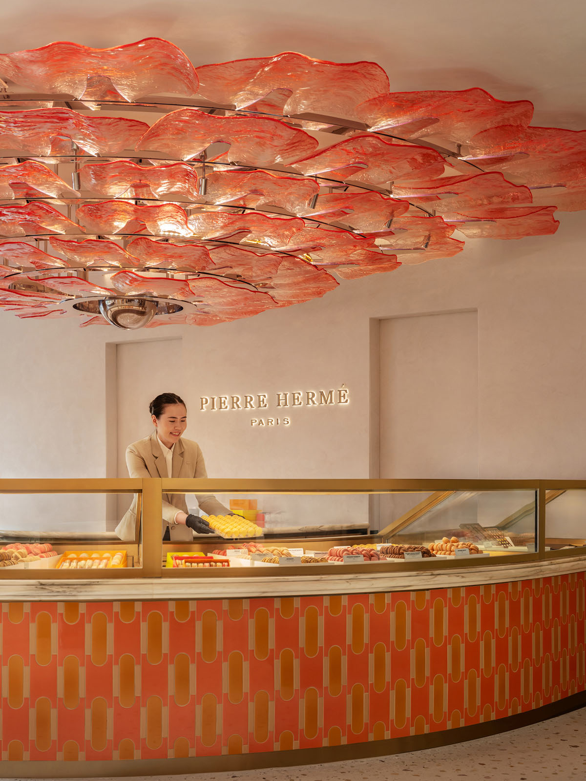 Banco circolare centrale con esposizione dolci e layout curvilineo