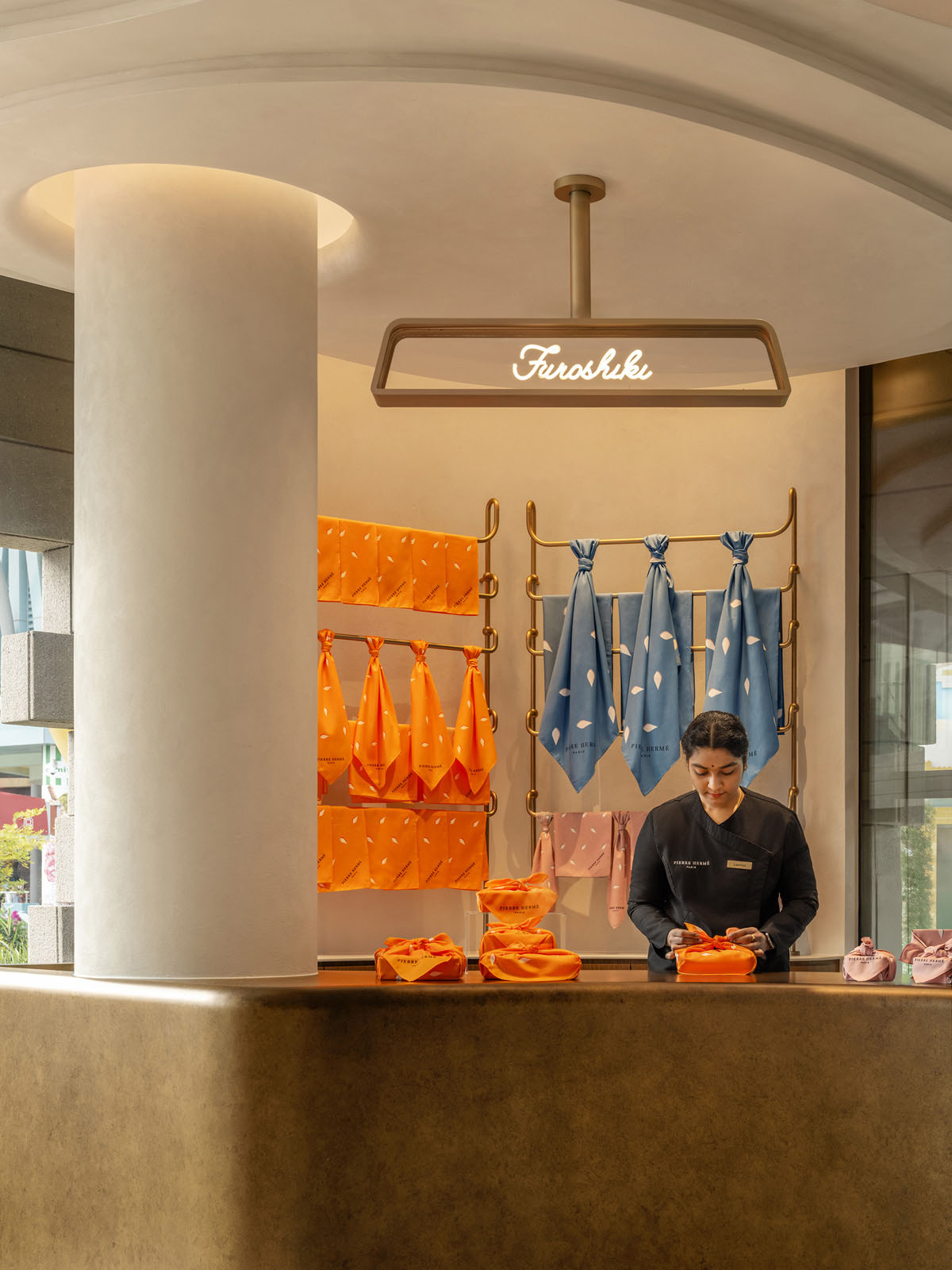 Area dining con sedute imbottite e tavoli nel flagship Pierre Hermé Singapore