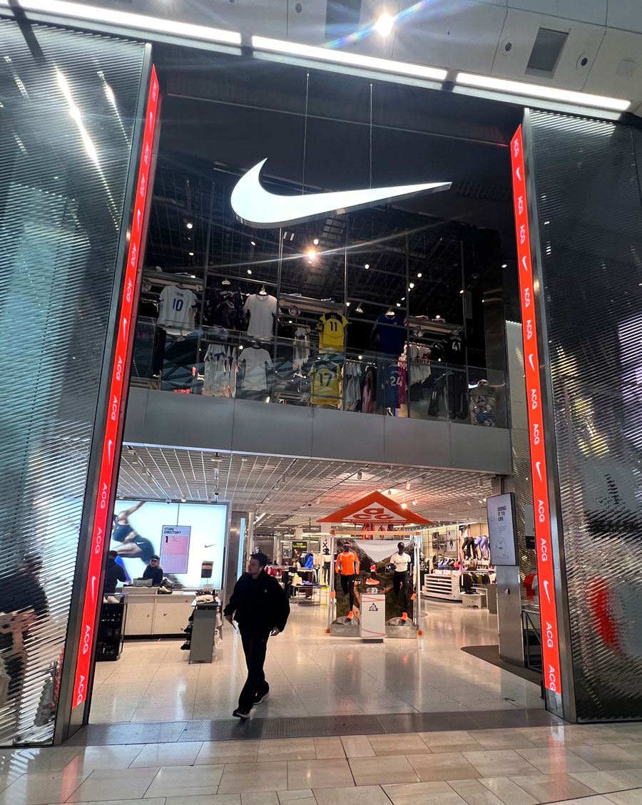Flagship Nike con portale luminoso e area dedicata alle collezioni sportive e calcio