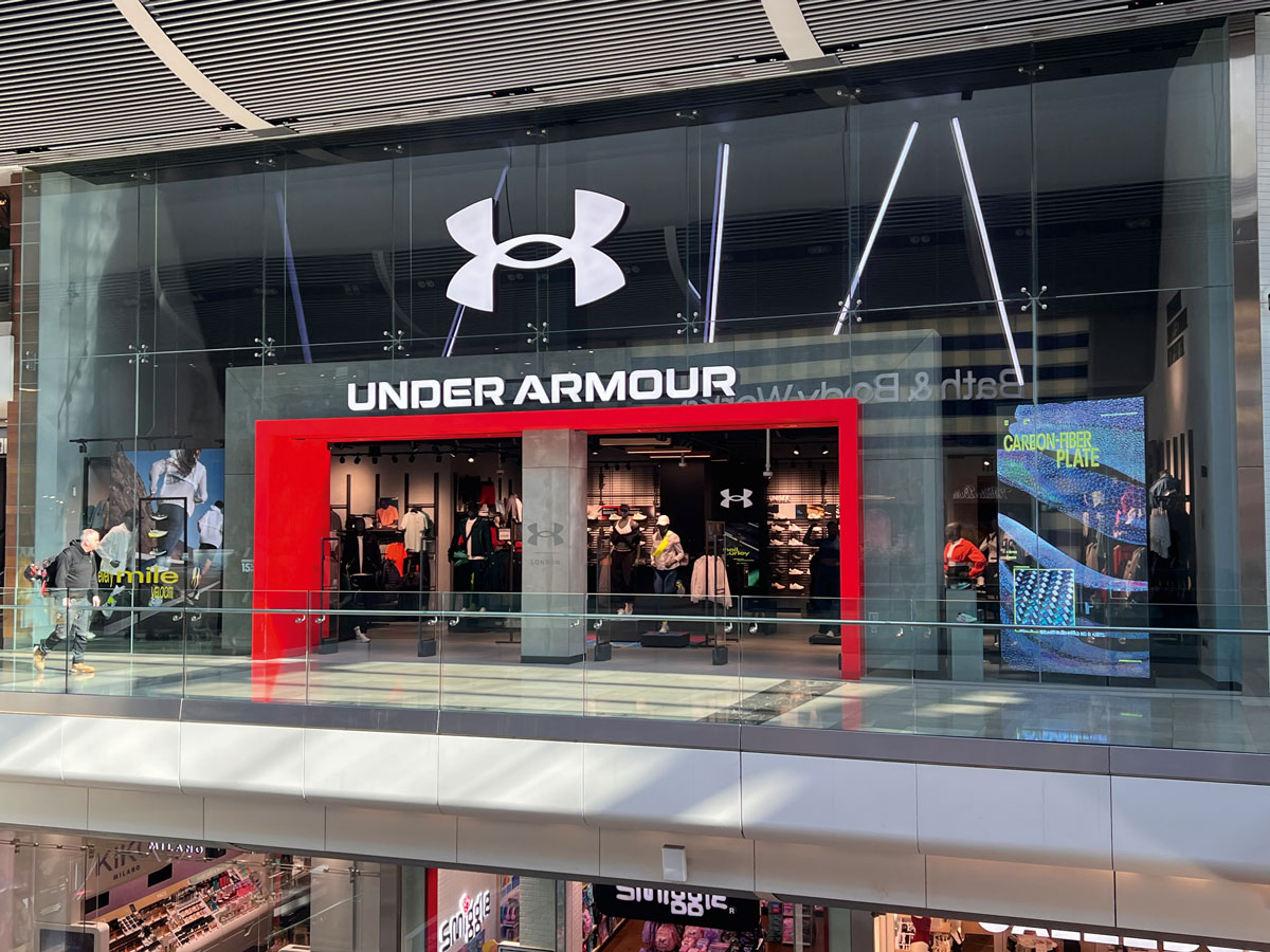 Store Under Armour nel mall Westfield con portale rosso retroilluminato e vetrina sportiva