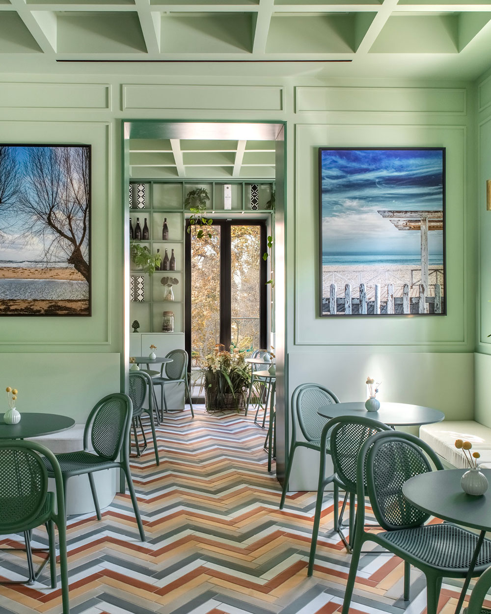 Dining area at Bar Galatea with marine artworks, green seating and Mediterranean interior palette