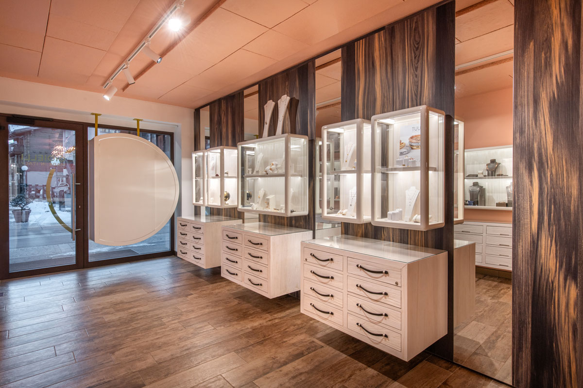 Display area of Esa Jewelry Store in Livigno with illuminated showcases, wood-effect panels and custom jewelry furnishings