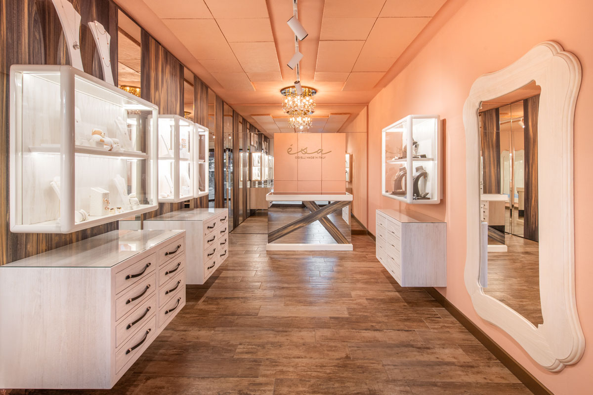 Interior of Esa Jewelry Store in Livigno with central display table, illuminated showcases and peach-colored walls