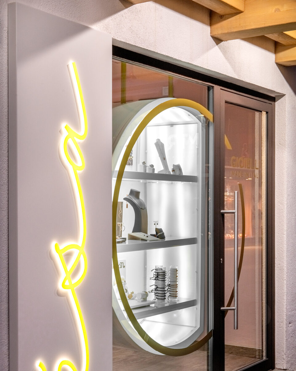 Detail of the Esa Jewelry Store storefront in Livigno with illuminated display and glowing facade signage