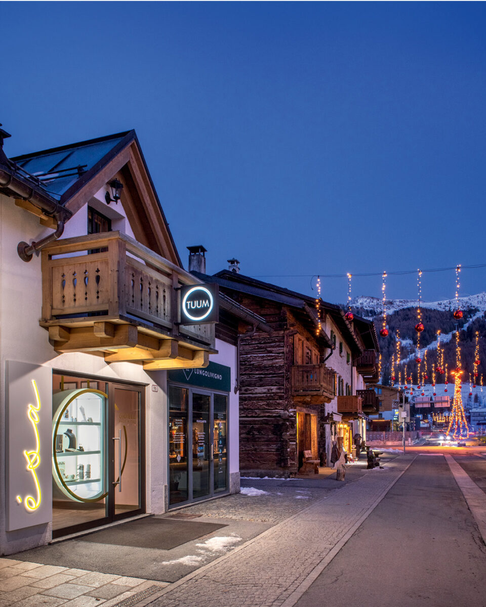 Facade of Esa Jewelry Store in Livigno with illuminated storefront and glowing signage in an alpine evening setting