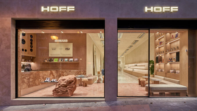 Ingresso del flagship store HOFF Velázquez a Madrid con vetrine su strada, area SNEAKS café e interni in pietra, legno e superfici materiche