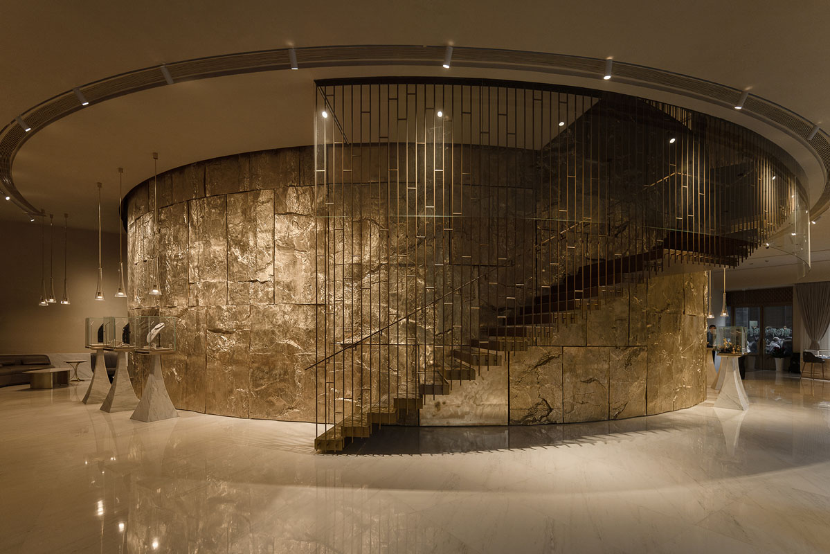 Monumental staircase and mineral surfaces inside the Lao Feng Xiang flagship designed by llLab in Shanghai