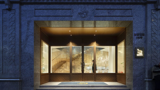 Ingresso del flagship jewelry store LFX-DELUXE TREASURE LOUNGE a Shanghai con facciata in pietra, vetrate e interni illuminati dal lighting design museale