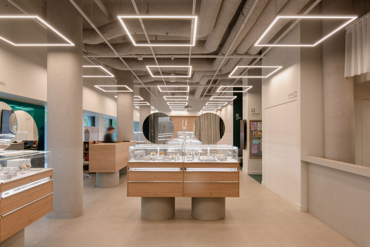 Entrance area of the MoJA Jewelry Museum with geometric lighting and light wood displays