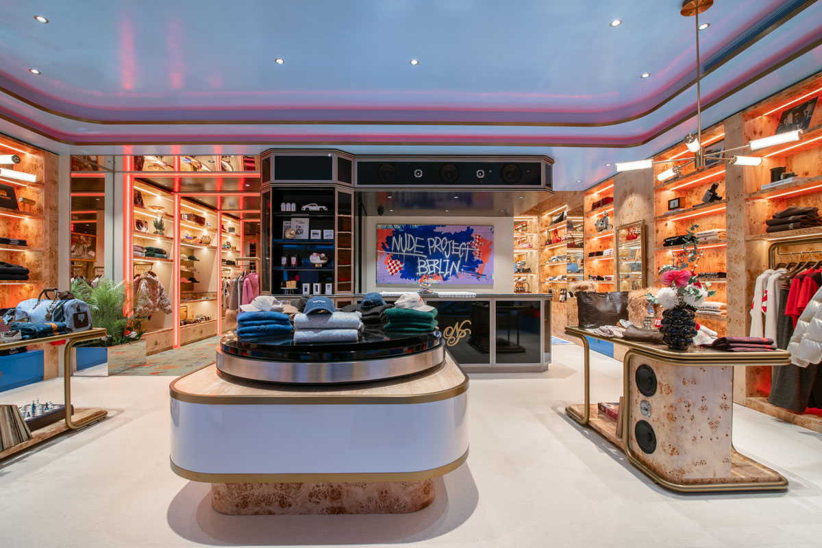 Main Lounge inside Nude Project Berlin flagship with burl wood furniture, integrated lighting and immersive retail displays designed by El Departamento