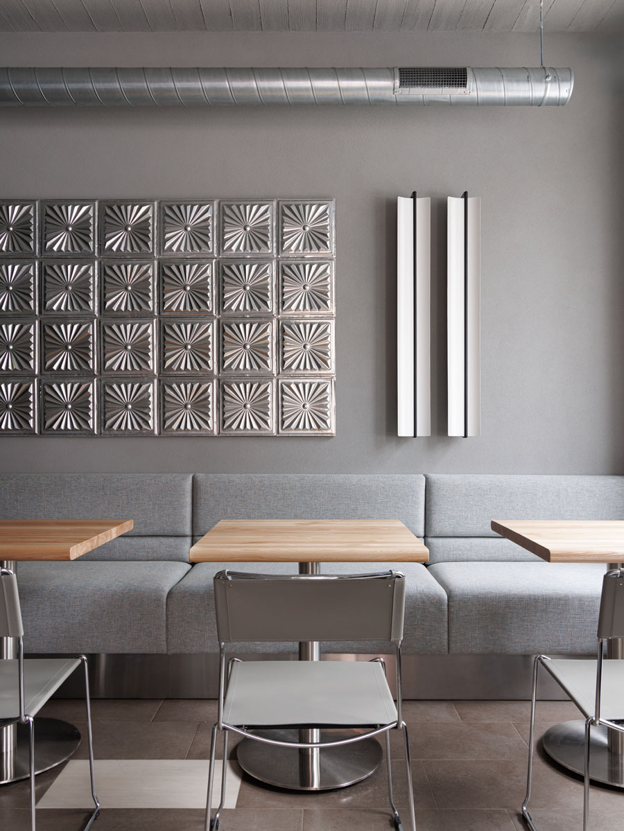 Tavolo circolare turchese inserito in un ambiente industriale minimale