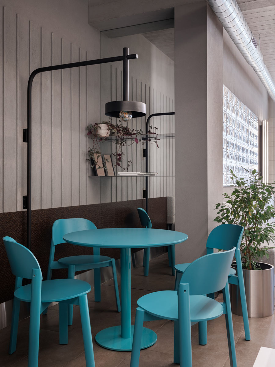 Interno del Portland Coffee con superfici specchianti e sedute turchesi
