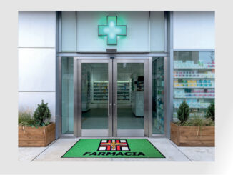 Ingresso di farmacia con zerbino tecnico personalizzato coordinato con l’identità visiva del punto vendita