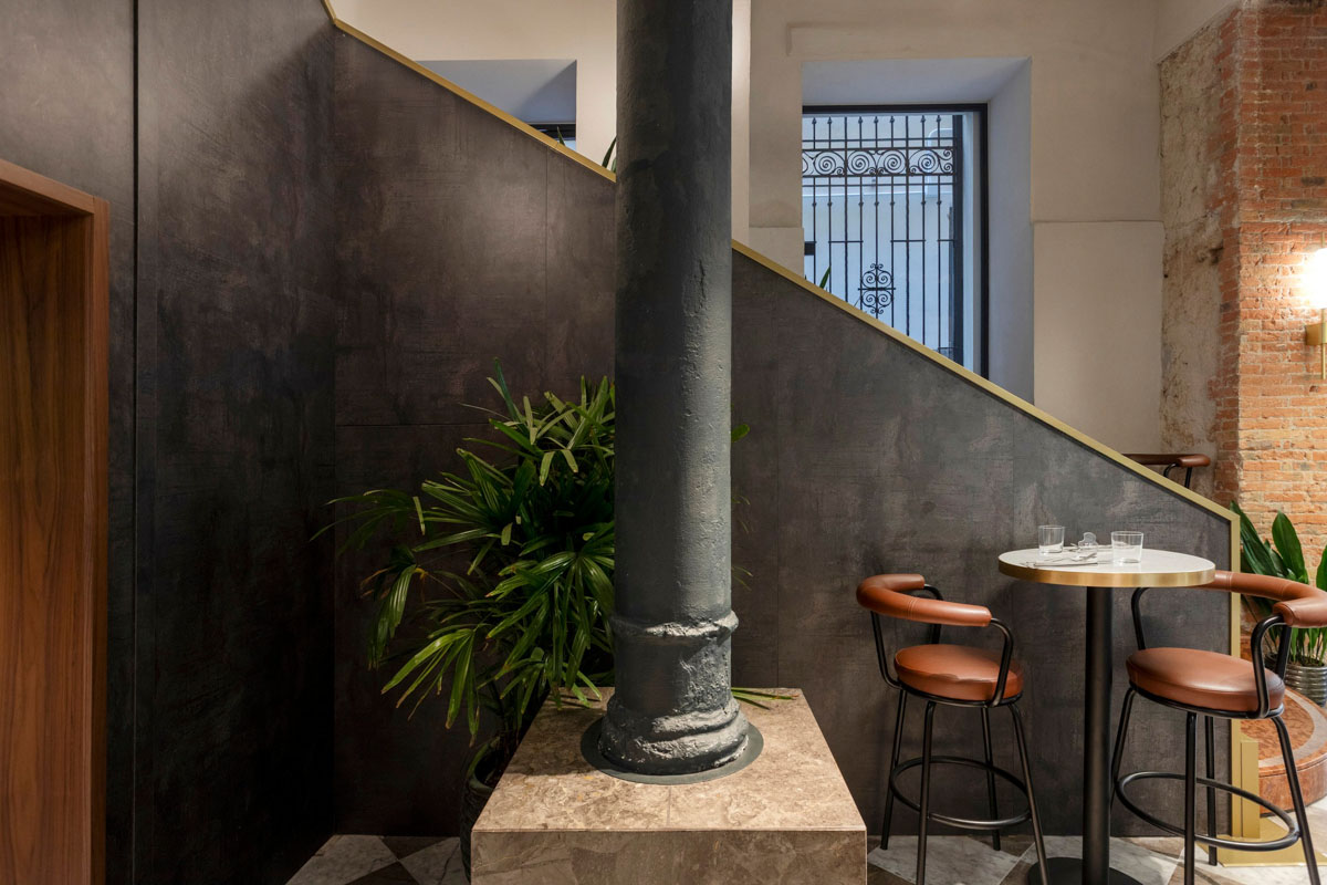 Zona dining con colonne in ghisa e rivestimenti materici nel Retrobottega di Prezzemolo & Vitale