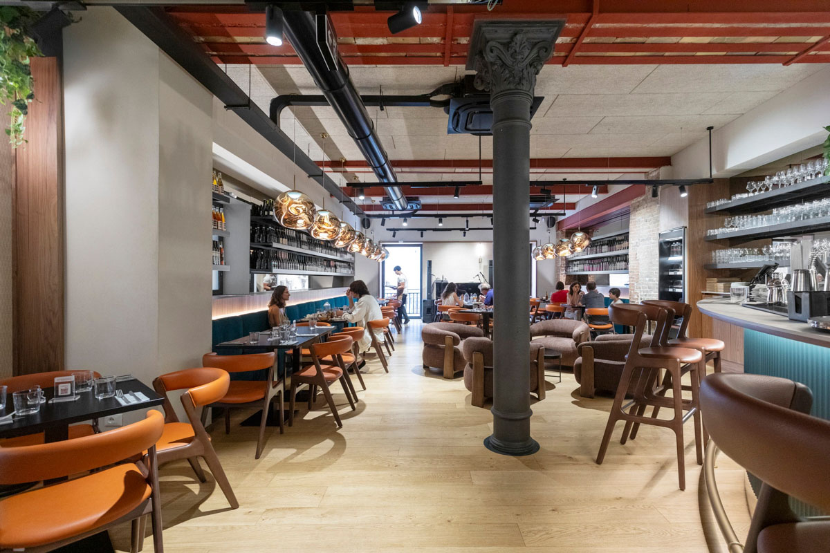 Sala wine bar del Retrobottega Prezzemolo & Vitale con parquet in legno, colonne in ghisa e illuminazione decorativa nel centro storico di Palermo