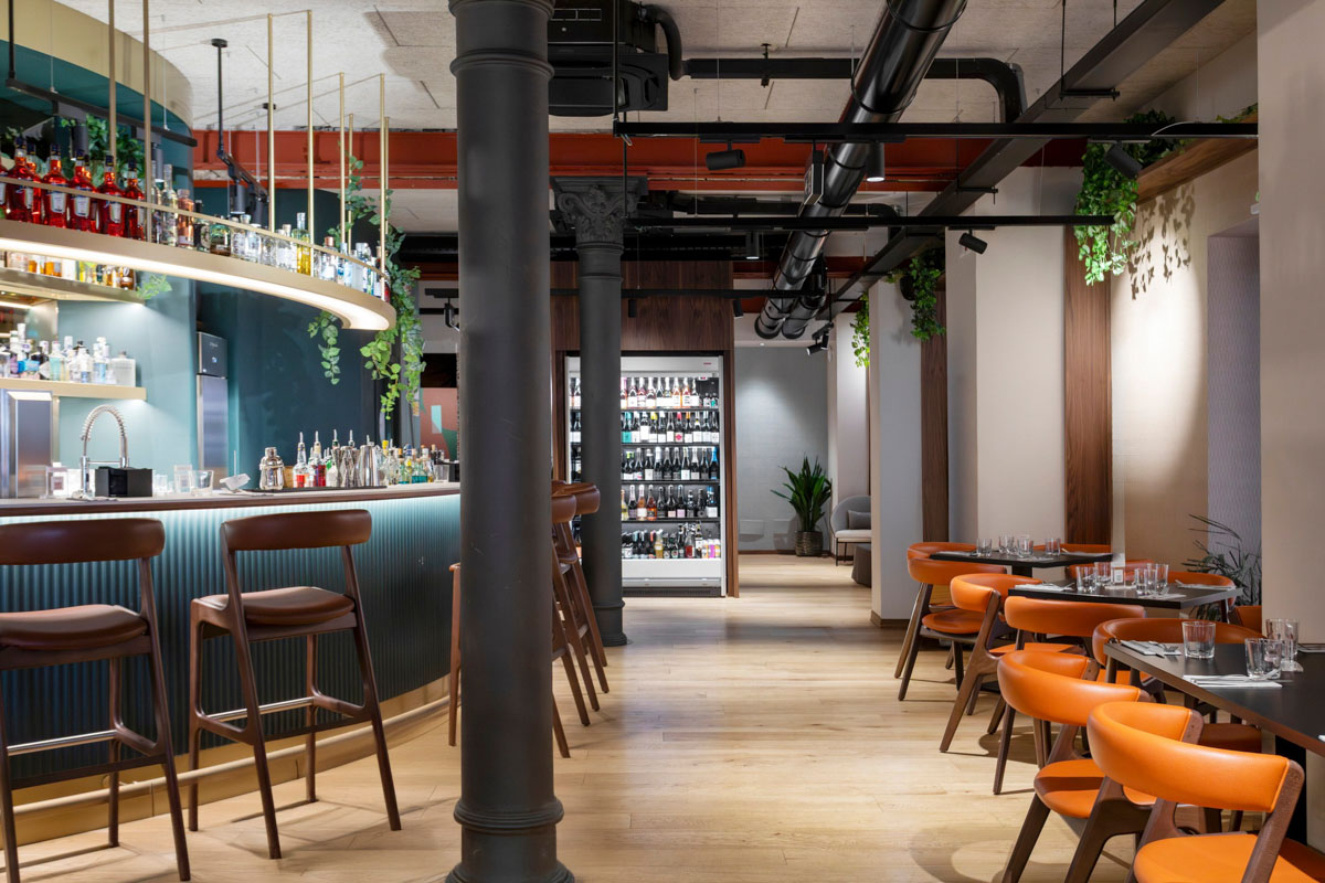 Sala wine bar del Retrobottega Prezzemolo & Vitale con parquet in legno, colonne in ghisa e illuminazione decorativa nel centro storico di Palermo