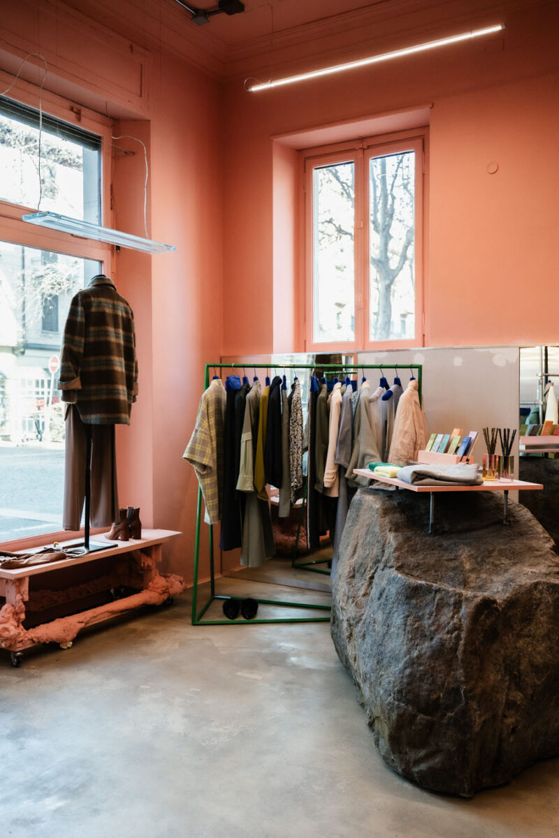 Monolithic display counter and garment rack define the exhibition path inside 16. Concept Store in Turin.