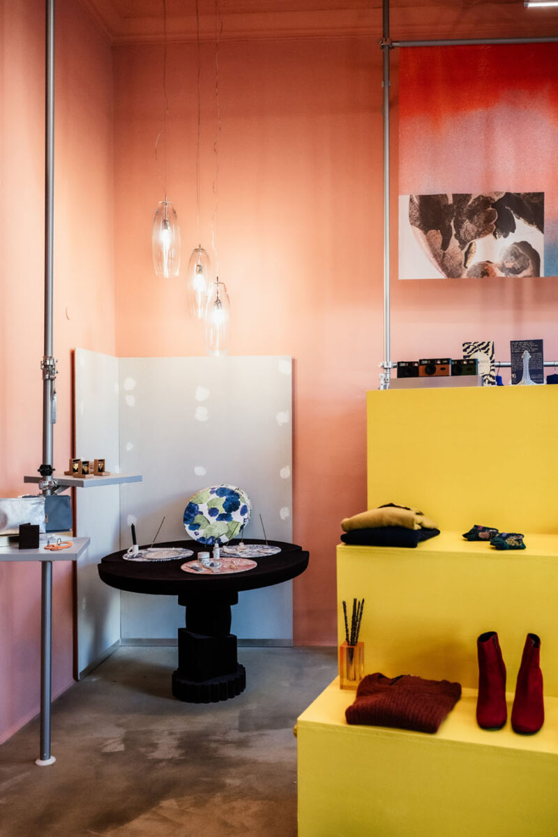 Coloured display volumes and central table define an area for design objects and accessories in 16. Concept Store in Turin.