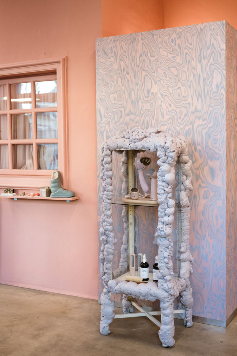 Sculptural display cabinet with a material structure in front of a decorative panelled volume inside 16. Concept Store in Turin.