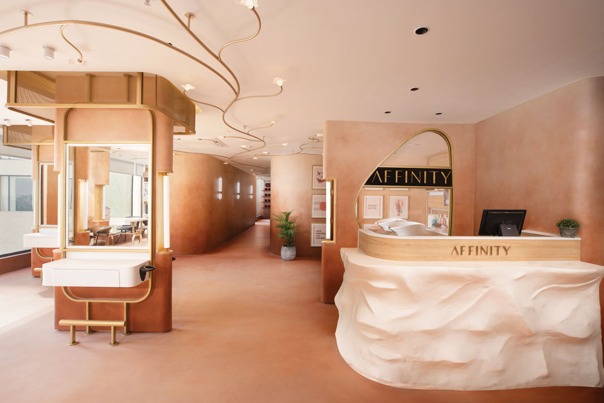 Sculptural reception desk at Affinity Salon featuring textured finishes and natural wood detailing.