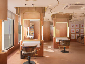 Postazioni styling di Affinity Salon a New Delhi con specchi retroilluminati, arredi su misura e illuminazione sinuosa integrata nel soffitto.