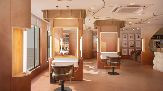 Postazioni styling di Affinity Salon a New Delhi con specchi retroilluminati, arredi su misura e illuminazione sinuosa integrata nel soffitto.