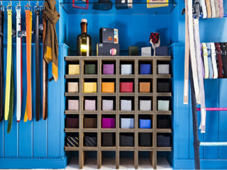 Arredo espositivo in cartone riciclato con struttura modulare a griglia per l'organizzazione di accessori moda, integrato in un concept retail orientato alla sostenibilità.