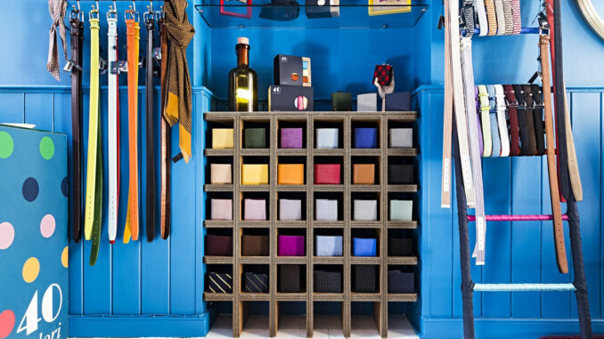 Arredo espositivo in cartone riciclato con struttura modulare a griglia per l'organizzazione di accessori moda, integrato in un concept retail orientato alla sostenibilità.