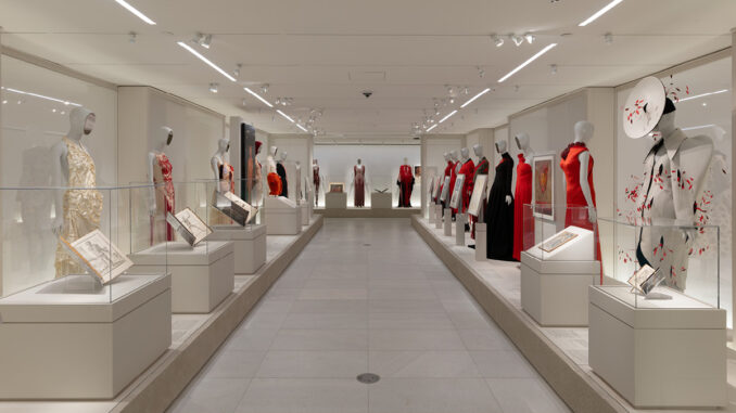Percorso espositivo della mostra Costume Art al Metropolitan Museum of Art con manichini Bonaveri, abiti contemporanei, teche museali e opere d'arte disposte lungo l'asse centrale della galleria.