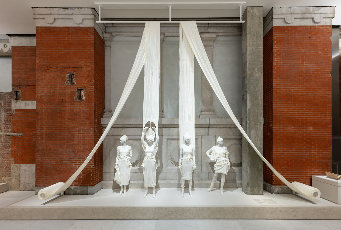 Installation view of the Costume Art exhibition at the Metropolitan Museum of Art featuring Bonaveri mannequins and a suspended textile installation within the museum galleries.